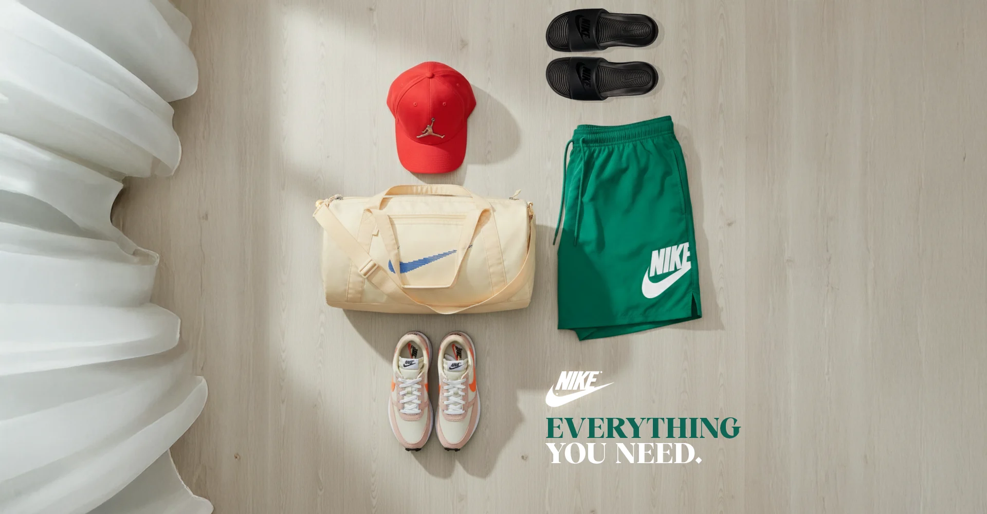 Ensemble de vêtements et accessoires de sport comprenant chaussures, sac, casquette, short et sandales présentés à plat de lamarque NIKE